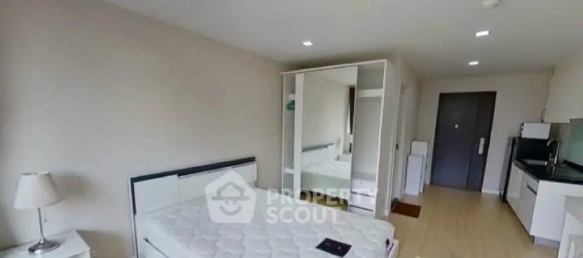 Modern bedroom with mirrored wardrobe and compact kitchen area