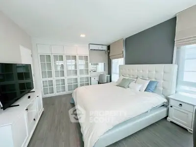 Spacious modern bedroom with elegant decor and ample natural light