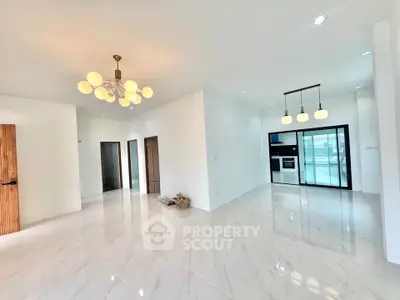 Spacious modern living area with elegant lighting and sleek kitchen design.