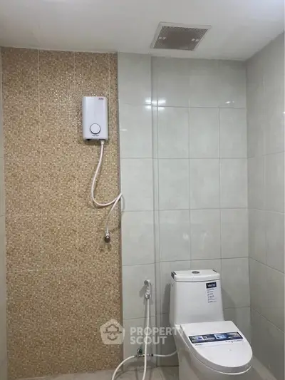 Modern bathroom with tiled walls and water heater, featuring a sleek toilet design.