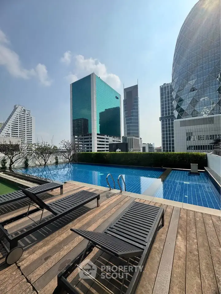 Luxurious rooftop pool with stunning cityscape views in a modern high-rise building.