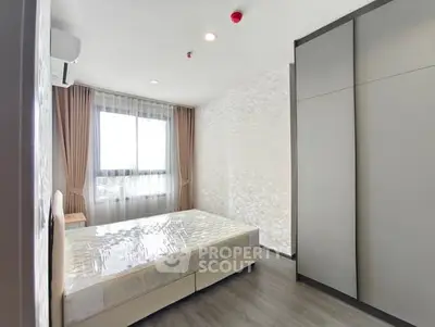 Modern bedroom with large window and sleek wardrobe design