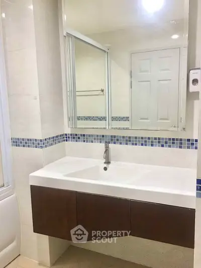 Modern bathroom with sleek vanity and large mirror in a stylish home.