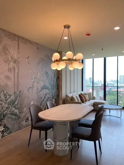 Stylish living room with modern chandelier and panoramic city view, featuring elegant wallpaper and cozy seating.