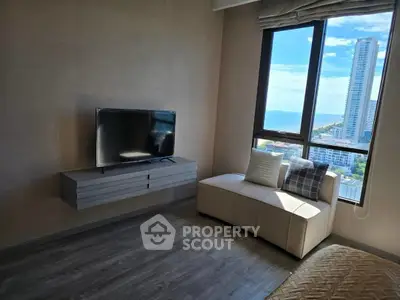 Modern living room with sleek TV setup and stunning city view from large window.