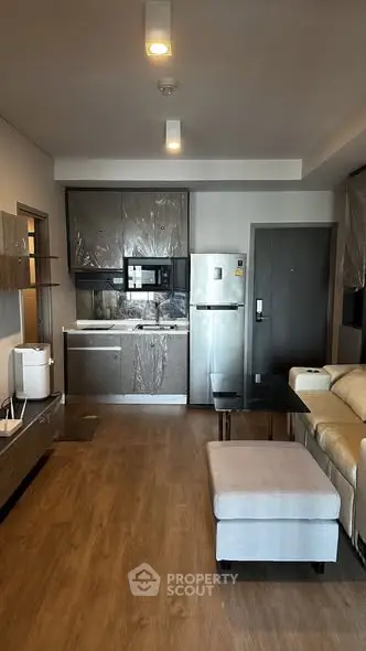Modern open-layout kitchen and living area with sleek appliances and cozy seating.