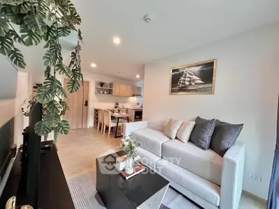 Modern living room with cozy sofa and stylish decor, open layout to dining area.