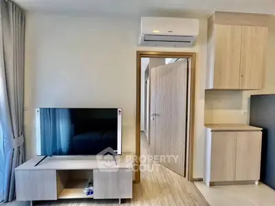 Modern living room with sleek TV stand and air conditioning unit, featuring light wood finishes and neutral tones.