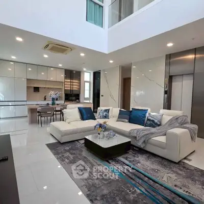 Luxurious modern living room with elegant decor and open kitchen layout, featuring sleek furniture and stylish design.