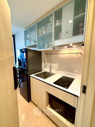 Modern compact kitchen with sleek appliances and ample storage in a stylish apartment.