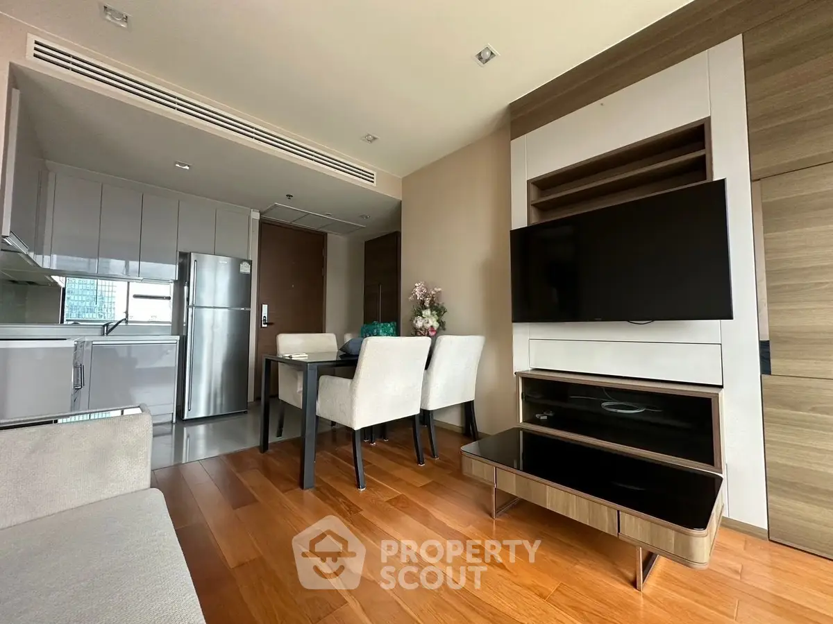 Modern living room with sleek furniture and open kitchen layout in a stylish apartment.