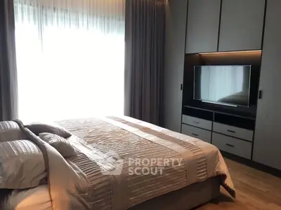 Luxurious bedroom with modern decor and large window for natural light.