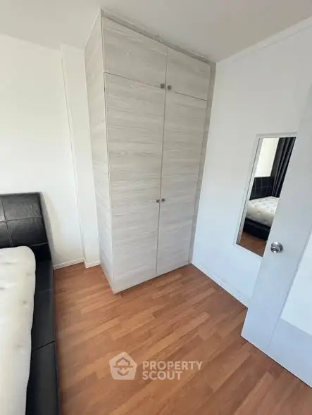 Modern bedroom with sleek wardrobe and hardwood flooring