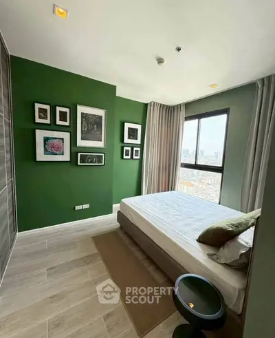 Stylish bedroom with green accent wall and city view, perfect for modern living.