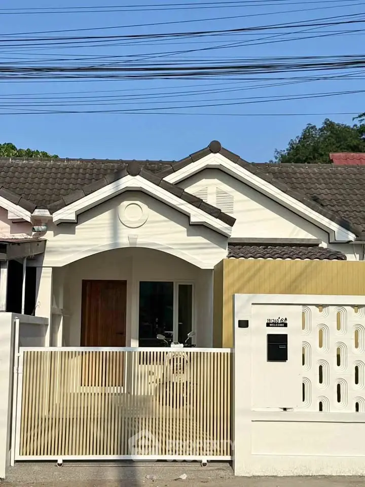 Charming single-story home with modern facade and gated entrance, perfect for family living.