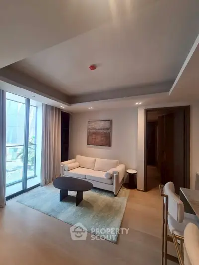 Modern living room with elegant decor and large windows offering natural light.