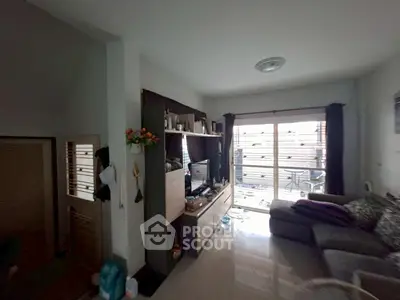 Cozy living room with modern decor and natural light from large windows.