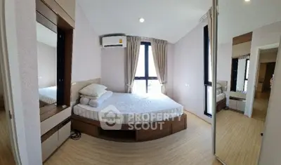 Spacious bedroom with modern design and large windows offering natural light