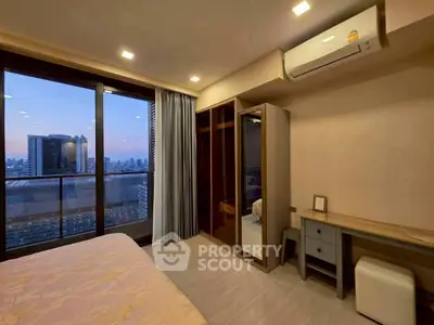 Modern bedroom with city view and balcony access in high-rise apartment.