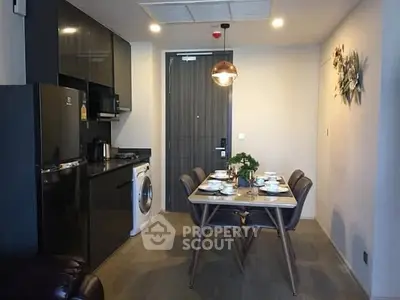 Modern kitchen with dining area, featuring sleek appliances and stylish decor.