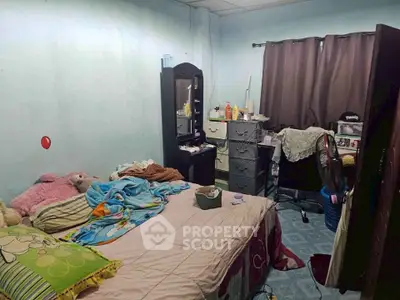 Cozy bedroom with personal touches, featuring a bed, dresser, and workspace, ideal for comfortable living.