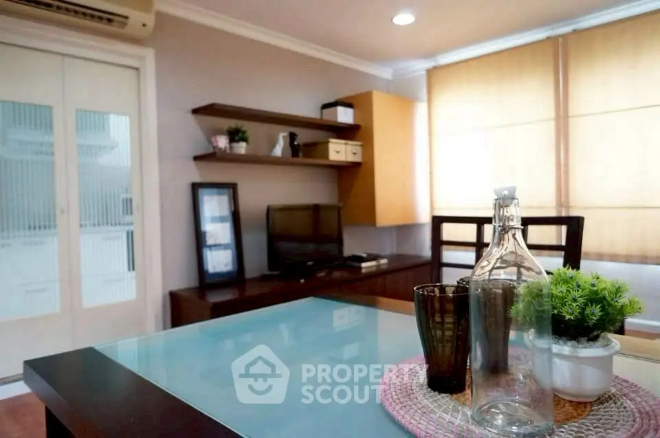 Modern living room with stylish decor and glass table, perfect for relaxation.