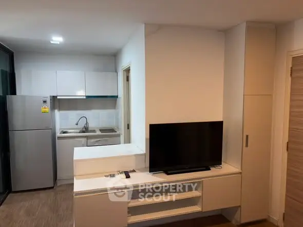 Modern compact kitchen with sleek appliances and integrated living area, perfect for urban living.