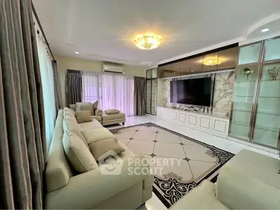 Luxurious living room with elegant decor, spacious seating, and a large TV, perfect for relaxation and entertainment.