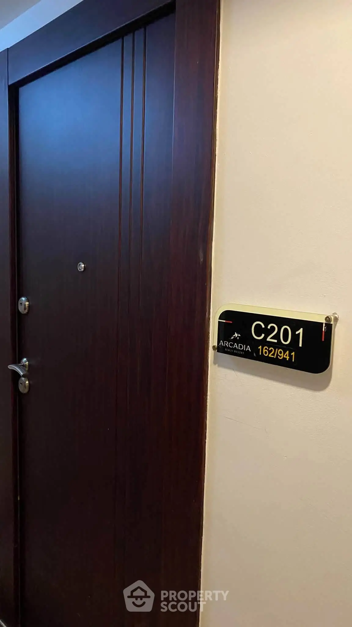Modern apartment entrance with sleek wooden door and stylish unit number plaque.