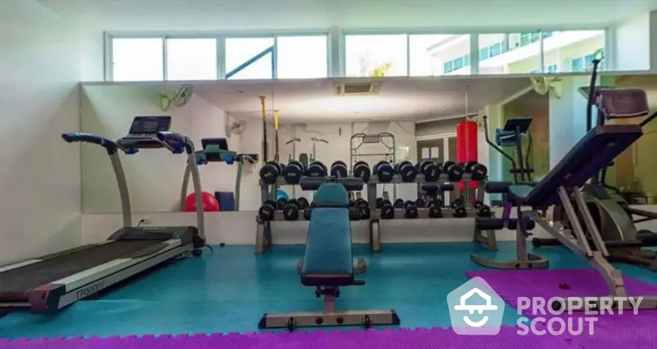 Modern gym with state-of-the-art equipment in luxury residential building.