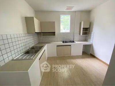Modern kitchen with sleek cabinetry and gas stove in a bright, airy space.