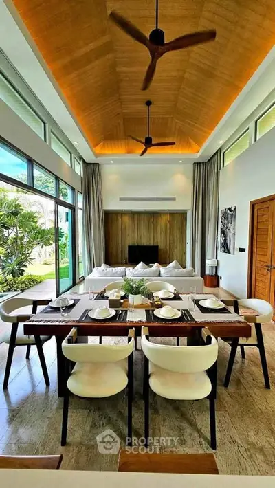 Luxurious open-plan living and dining area with high ceilings and modern decor, perfect for entertaining.