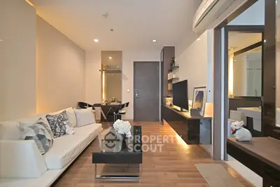 Modern living room with elegant decor and open layout, featuring stylish furniture and ambient lighting.