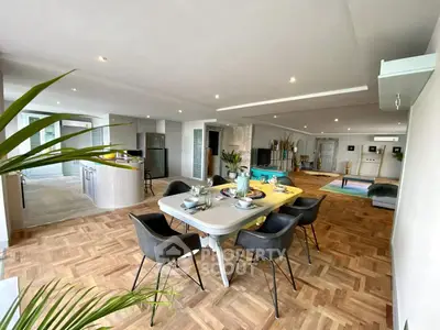 Spacious open-plan living and dining area with modern decor and parquet flooring.