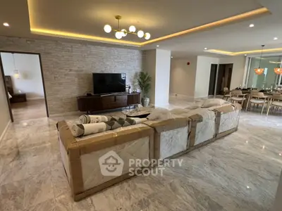 Luxurious living room with marble flooring and modern lighting in a spacious open layout.