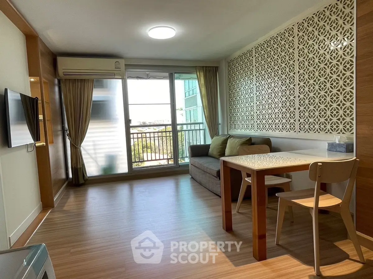 Modern living room with stylish decor and balcony access in a cozy apartment.