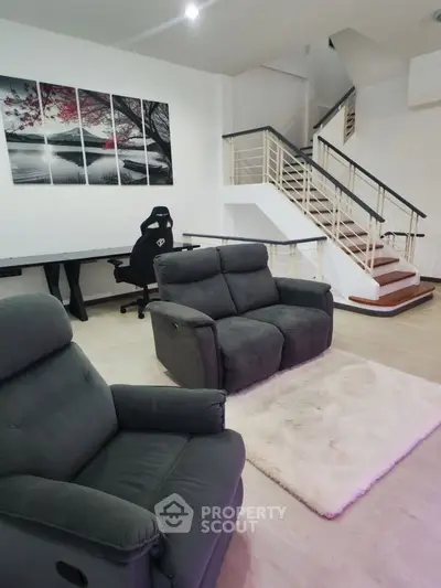 Spacious living room with modern furniture and stylish staircase in a contemporary home.