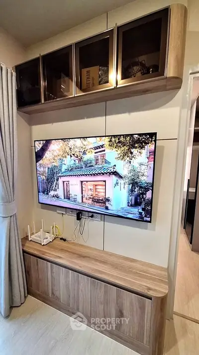 Modern living room with wall-mounted TV and stylish wooden cabinetry