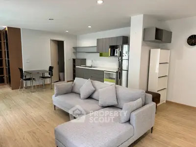 Modern open-plan living room with sleek kitchen and cozy seating area