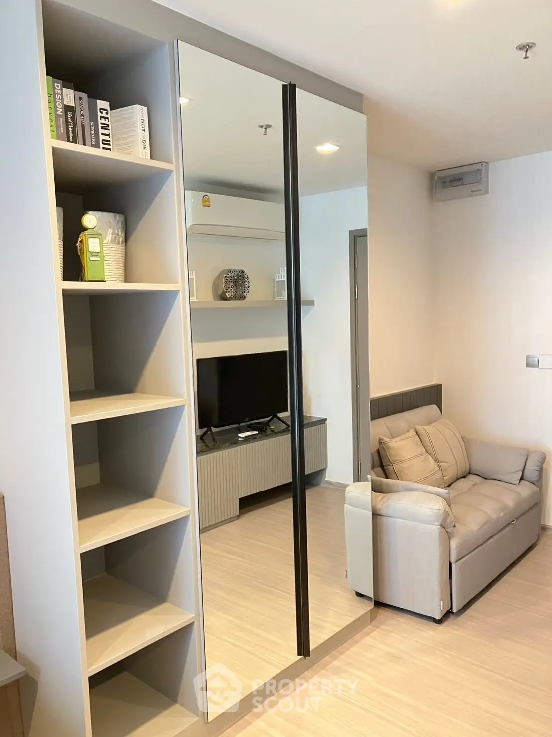 Modern living room with mirrored wardrobe and cozy sofa in stylish apartment