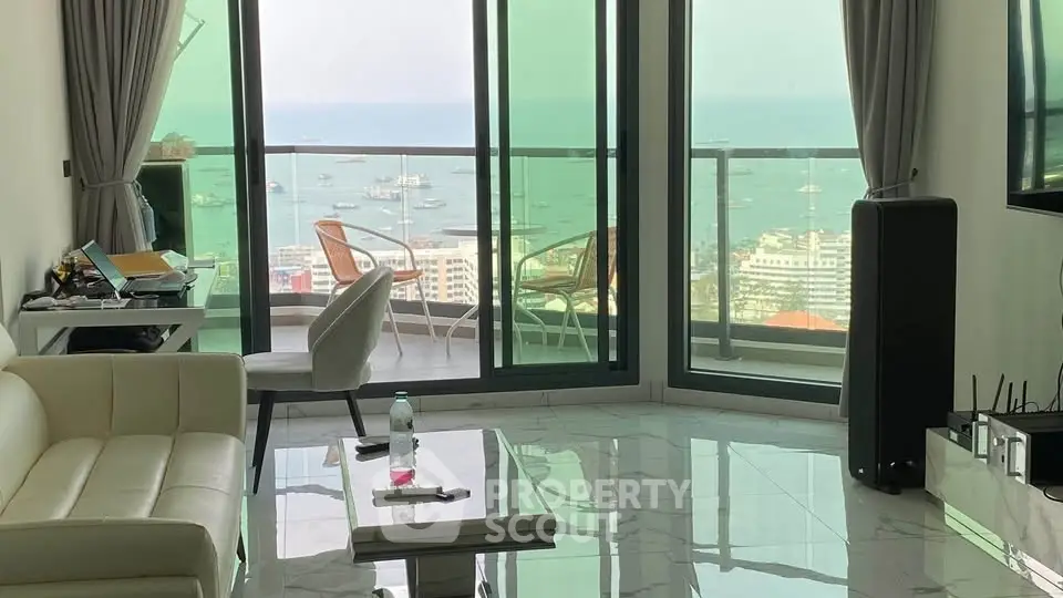 Luxurious living room with stunning ocean view and spacious balcony in modern apartment.