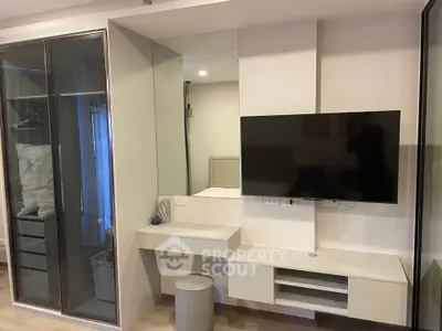 Modern bedroom with sleek TV setup and mirrored wardrobe