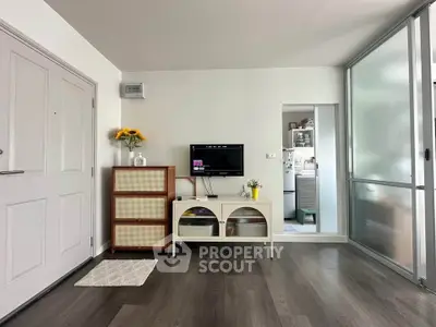 Modern living room with sleek flooring and stylish decor, featuring a TV and elegant storage solutions.