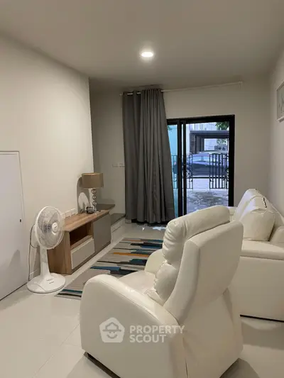Modern living room with white leather sofas and large window view