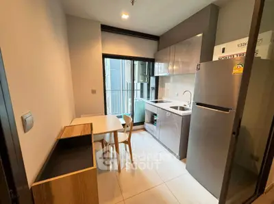 Modern kitchen with sleek cabinetry and dining area in a stylish apartment.