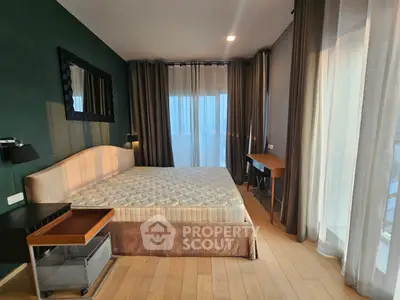 Spacious bedroom with modern decor and large windows offering natural light.