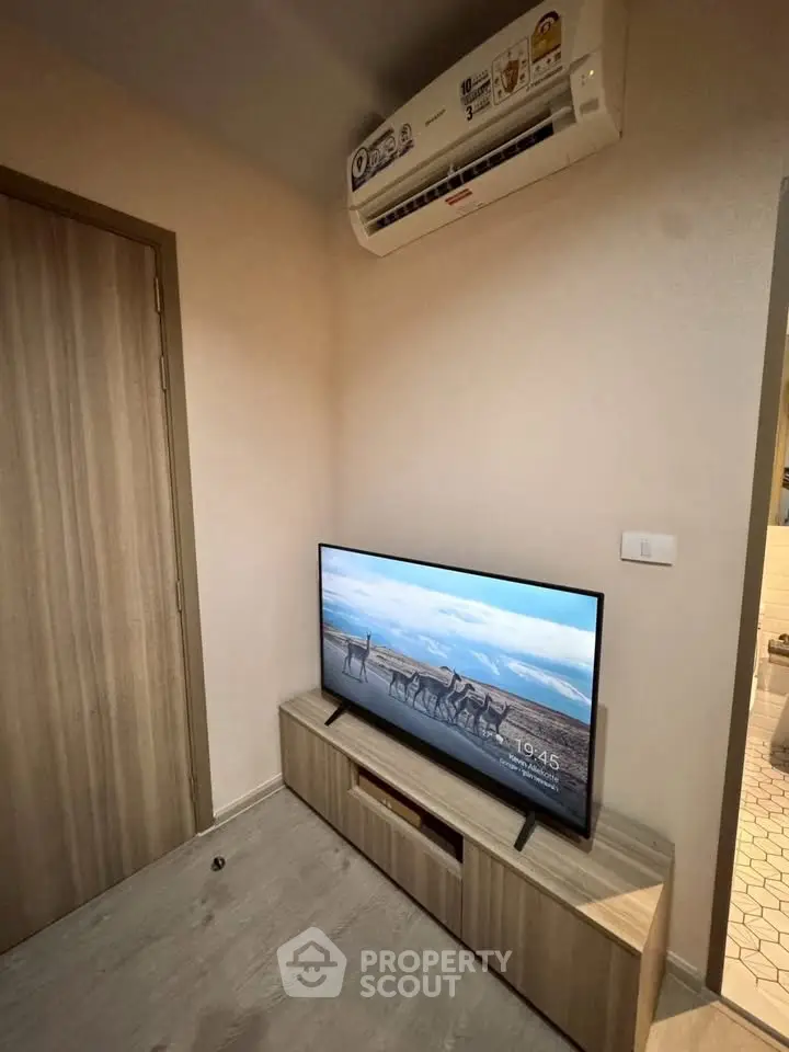 Modern living room corner with TV and air conditioning unit, perfect for cozy relaxation.