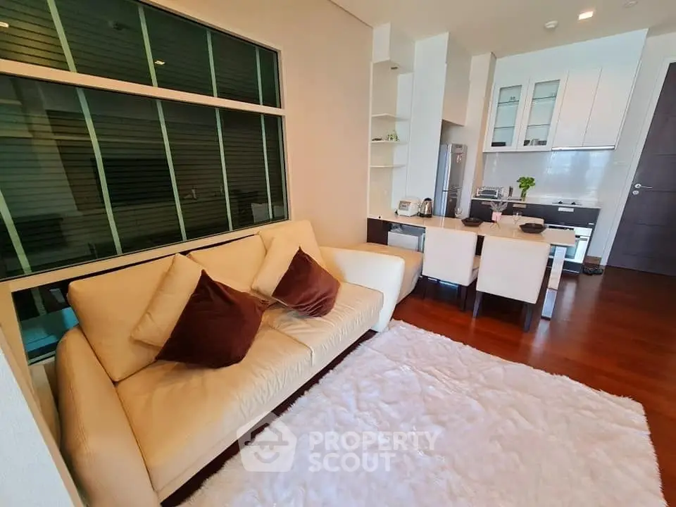 Modern living room with cozy sofa and stylish kitchen in open layout apartment.