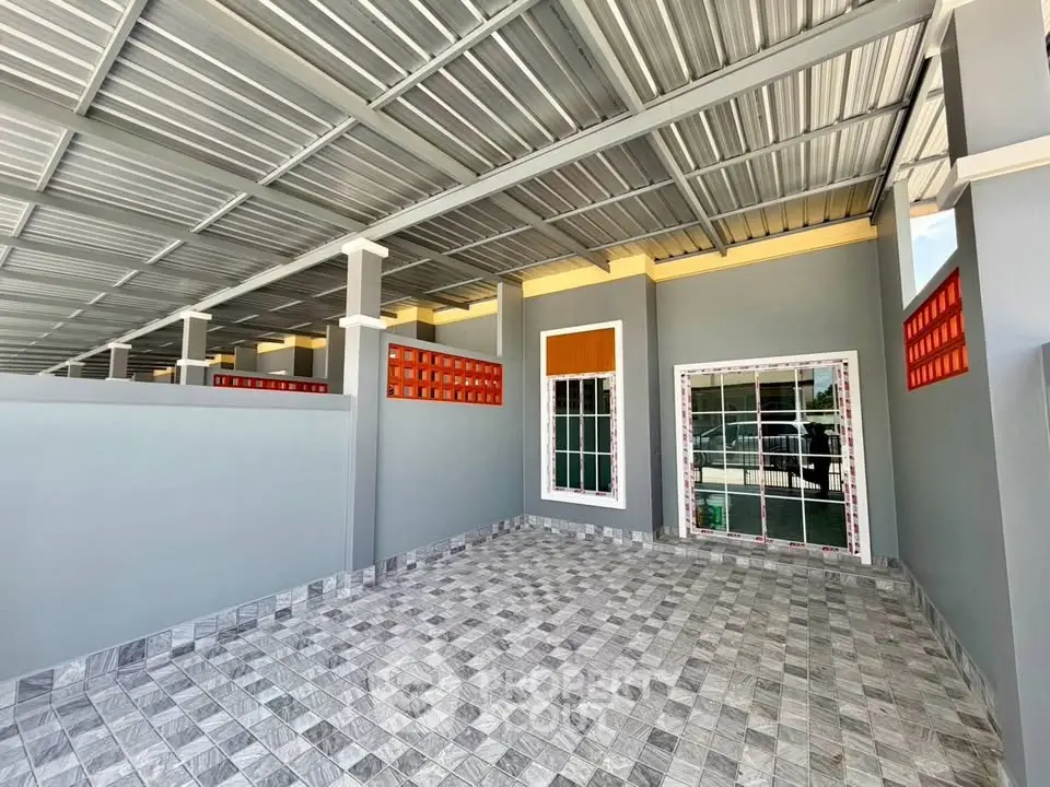 Spacious covered parking area with modern tiled flooring and sleek metal roofing.