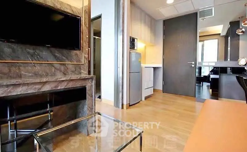 Modern living room with sleek design, featuring a wall-mounted TV and stylish glass coffee table.